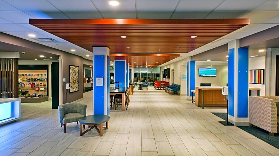 Hotel lobby with blue columns, wood ceiling, seating areas, and a front desk.
