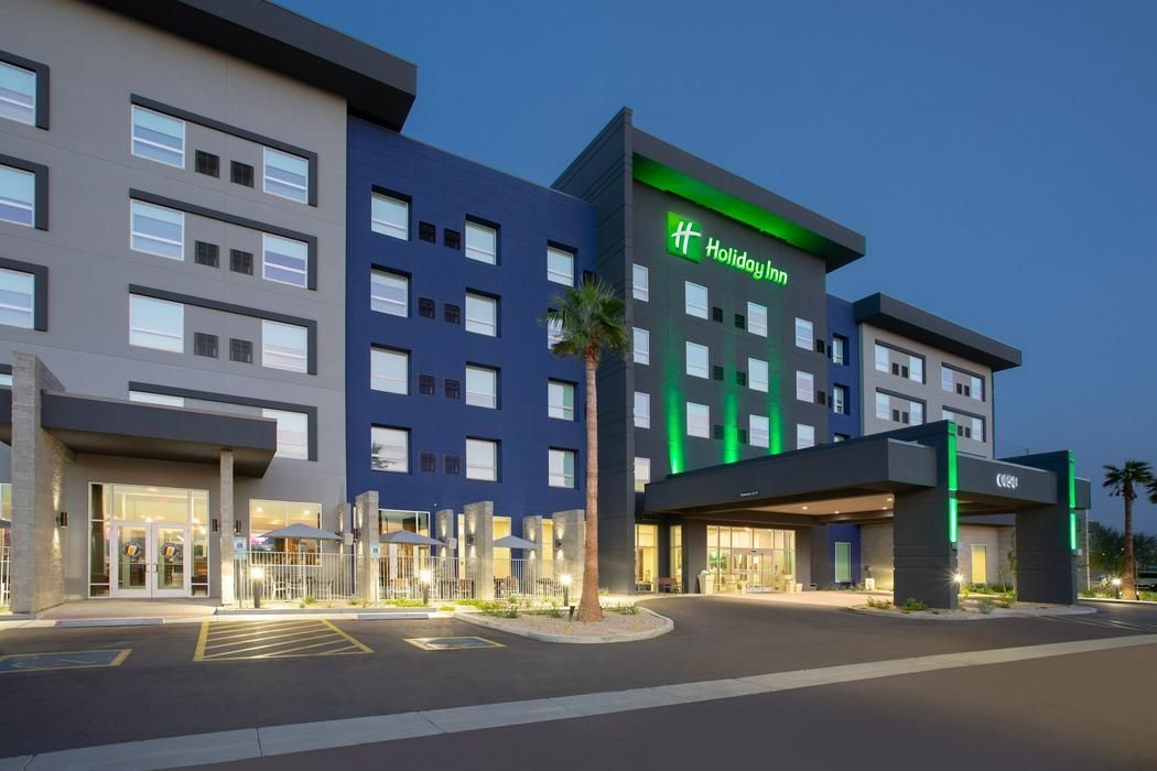 Holiday Inn Express hotel exterior at dusk, blue and gray facade, green accents.