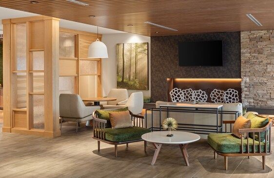 Lounge area with modern furniture, wood accents, and a stone accent wall.