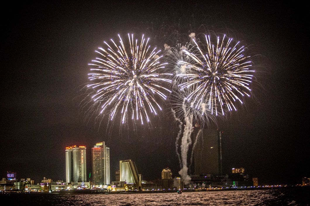 Fireworks exploding over a city skyline at night.
