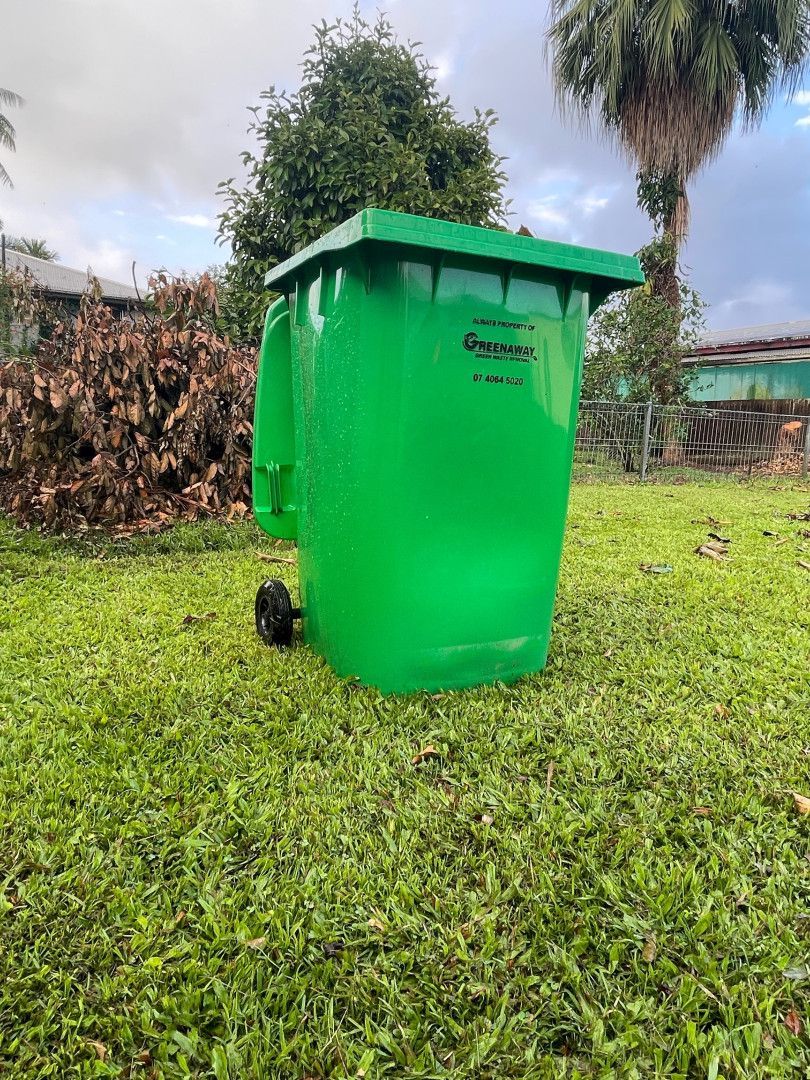 Green trash can with wheels on grass, outdoors. — Greenaway Green Waste Removal in Babinda, QLD