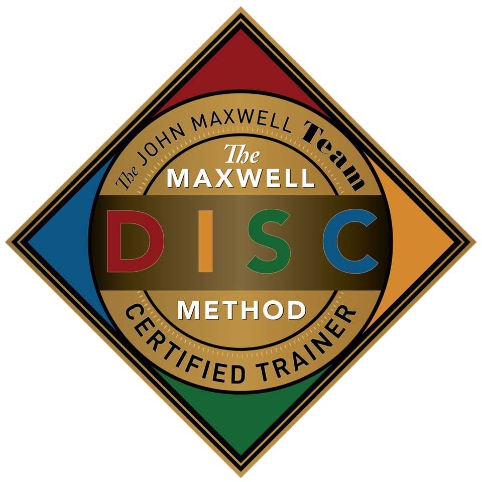 John Maxwell Team DISC Method Certified Trainer badge. Gold, diamond shape with colorful segments and text.