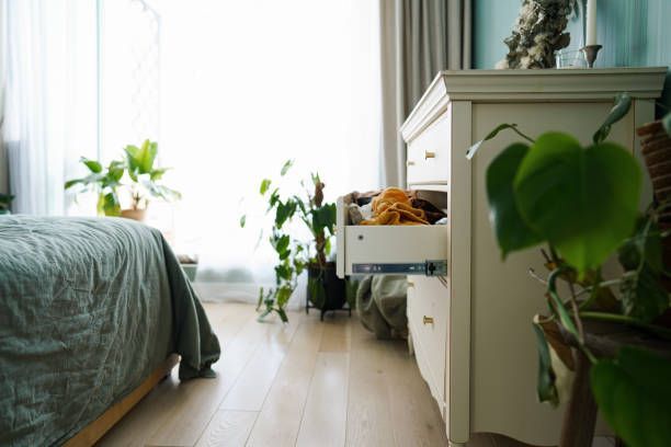 A bedroom with a bed and a dresser with a drawer open.