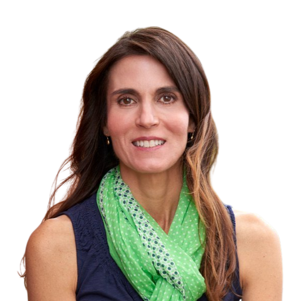 Woman with brown hair, wearing a pink blazer and white top, looking straight ahead.