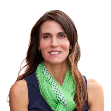 Woman with brown hair, wearing a pink blazer and white top, looking straight ahead.