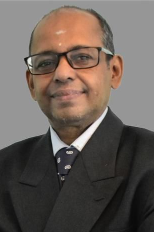 Middle-aged man with glasses and dark suit, smiling.