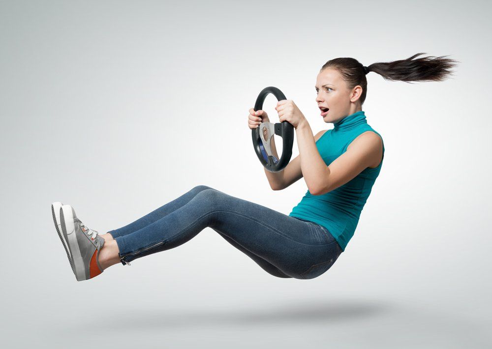 A woman is flying through the air while holding a steering wheel.