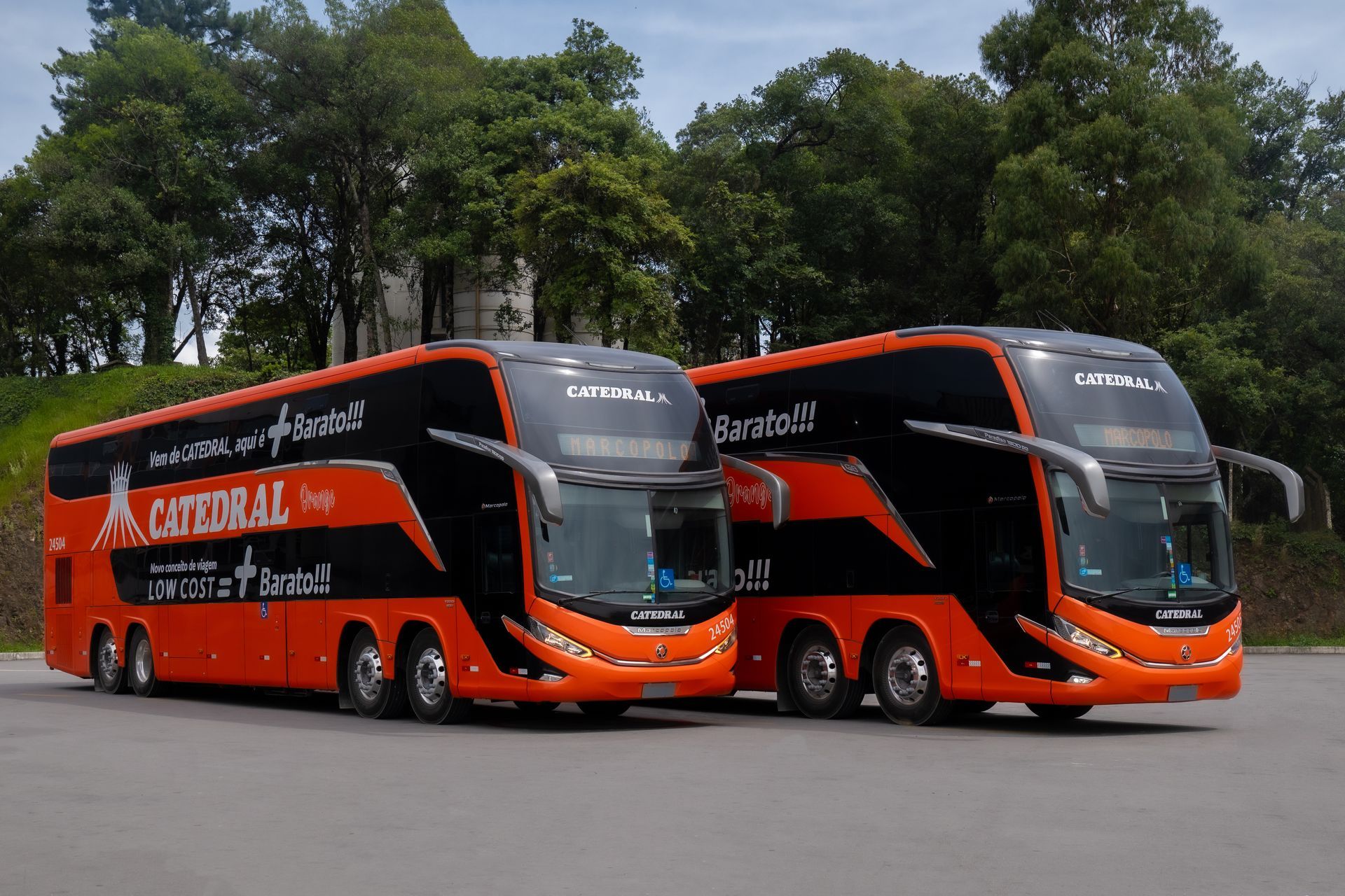 Dois ônibus de dois andares laranja da viação Catedral estacionados.