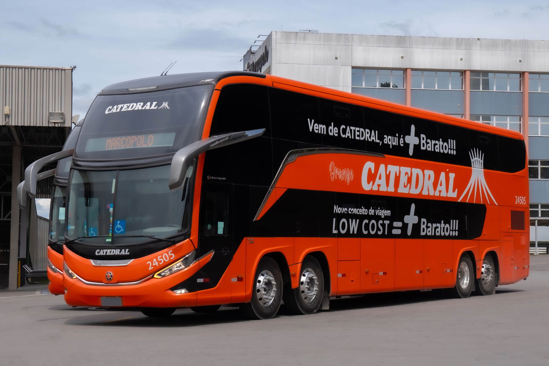 Ônibus Catedral de dois andares laranja e preto estacionado ao ar livre.