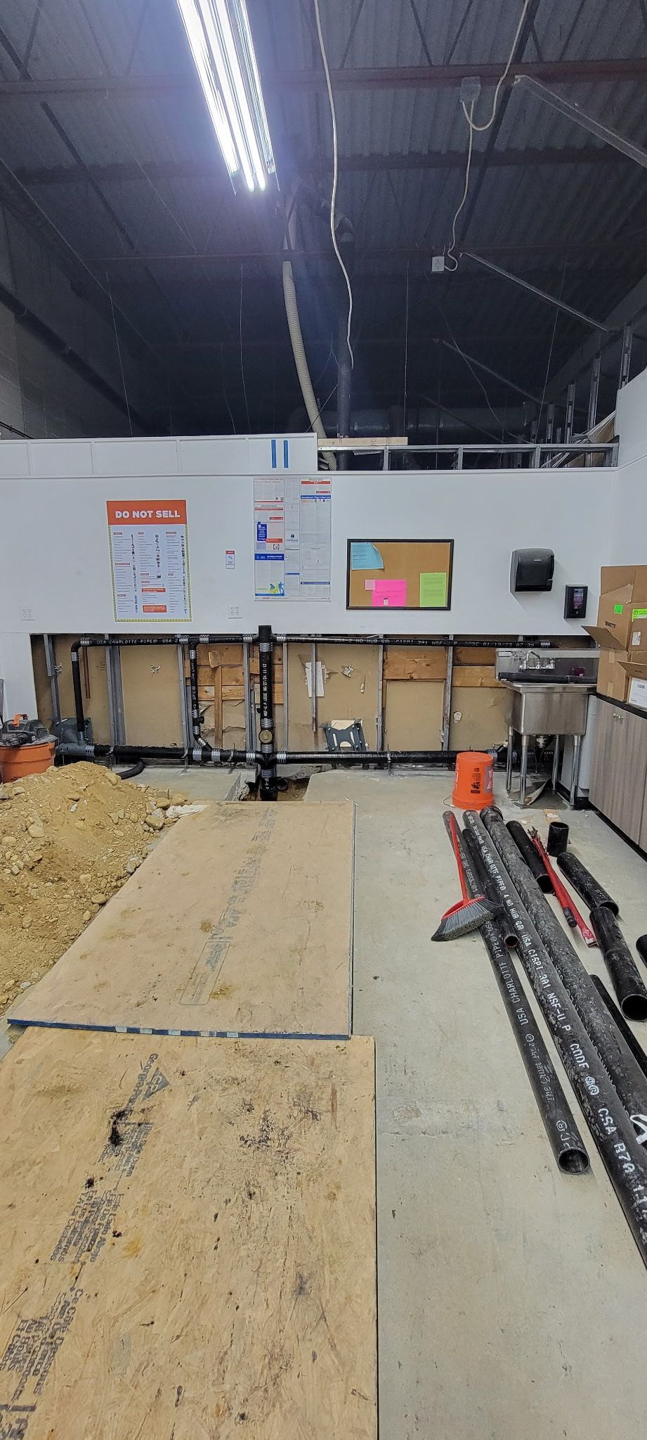 A warehouse with a lot of wood and boxes on the floor.
