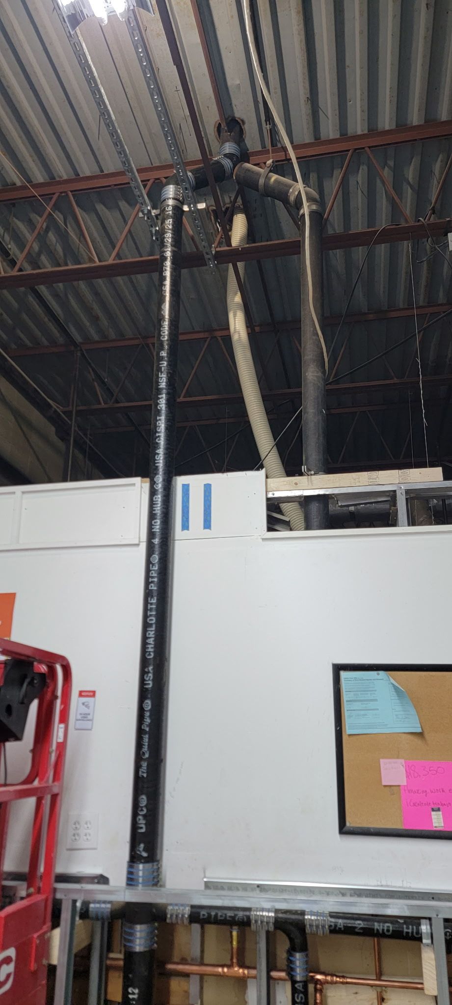 A hose is hanging from the ceiling of a warehouse.