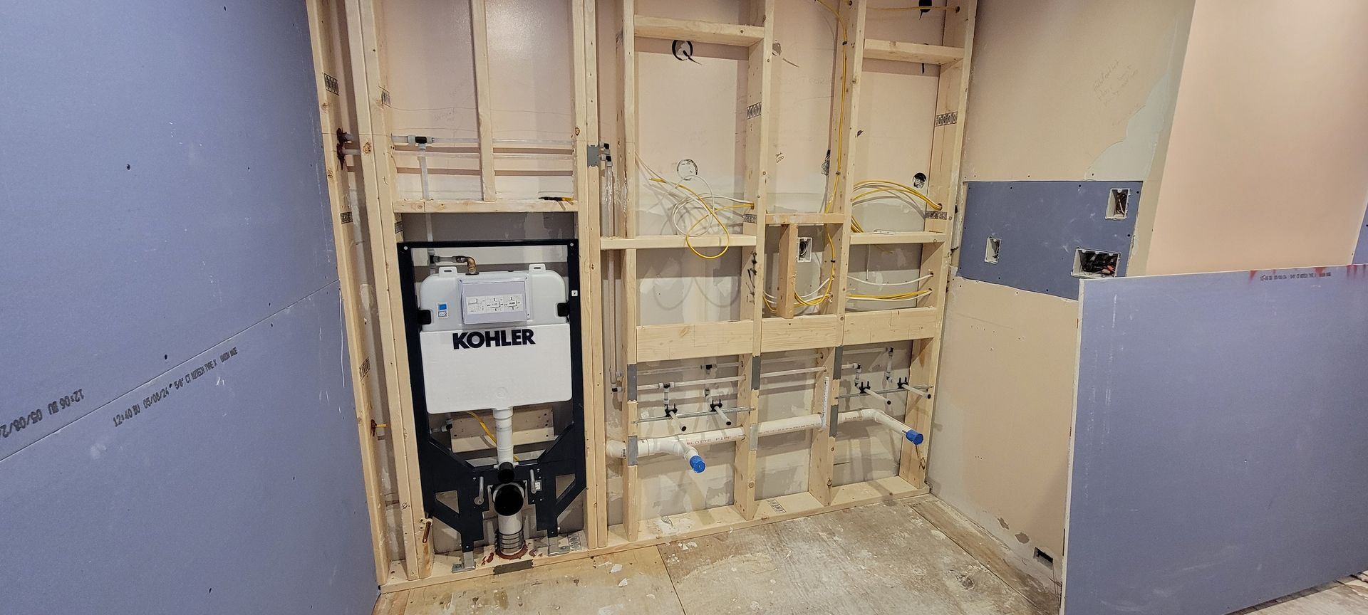 A bathroom under construction with a toilet in the wall.