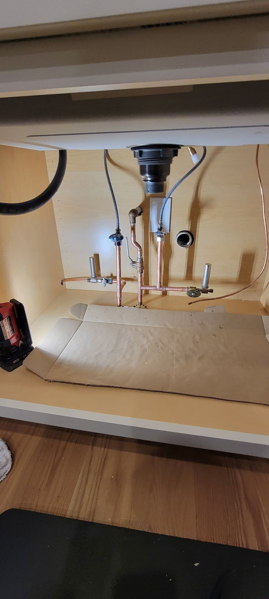 A sink is being installed under a cabinet in a kitchen.