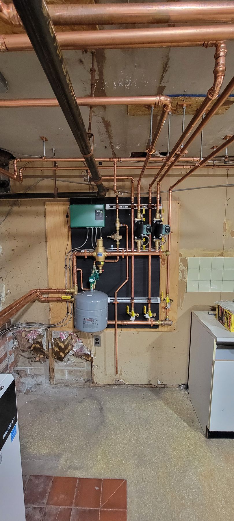 A room with a lot of copper pipes hanging from the ceiling.