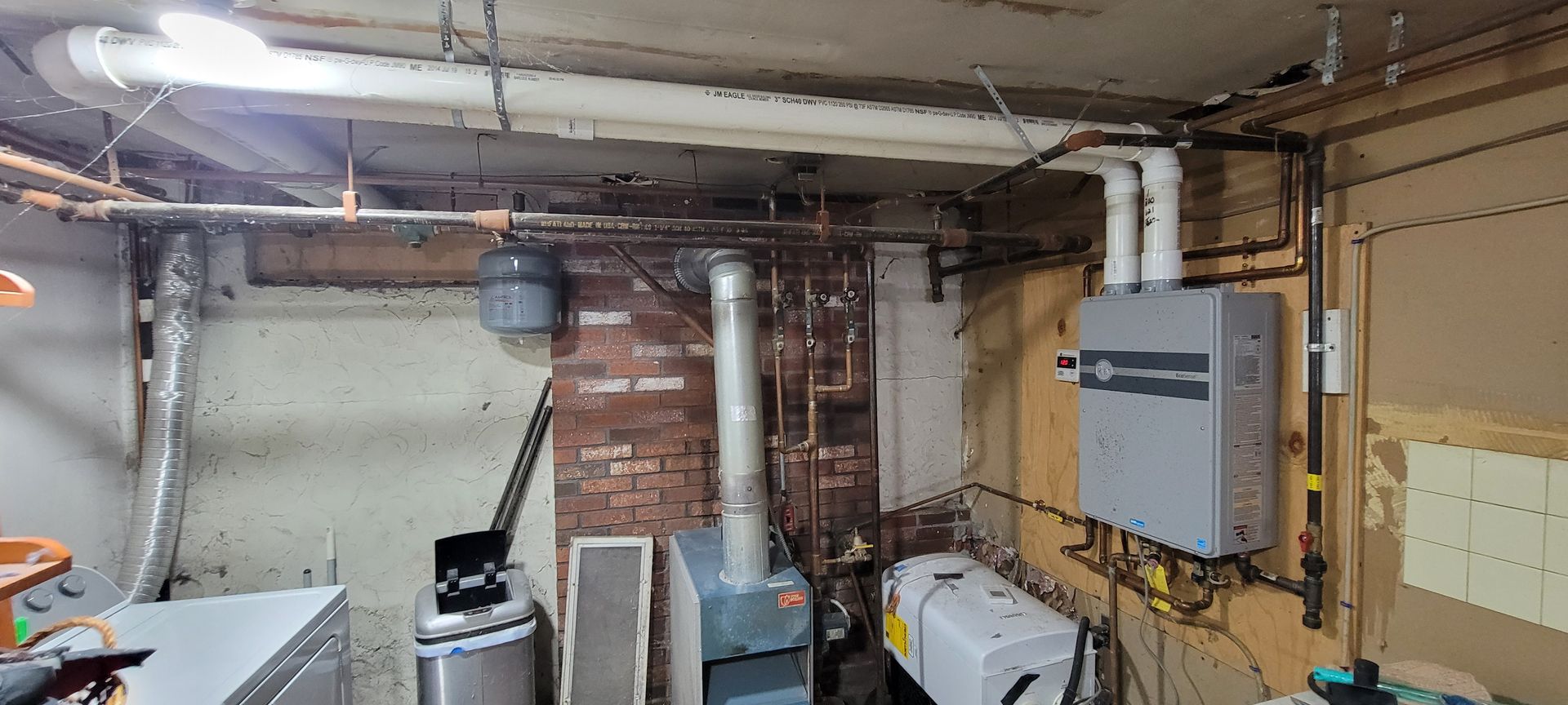 A basement with a stove and a boiler in it.