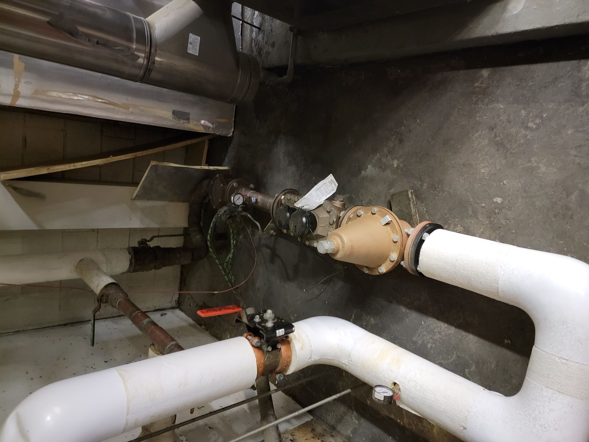 A room with a lot of pipes and a valve