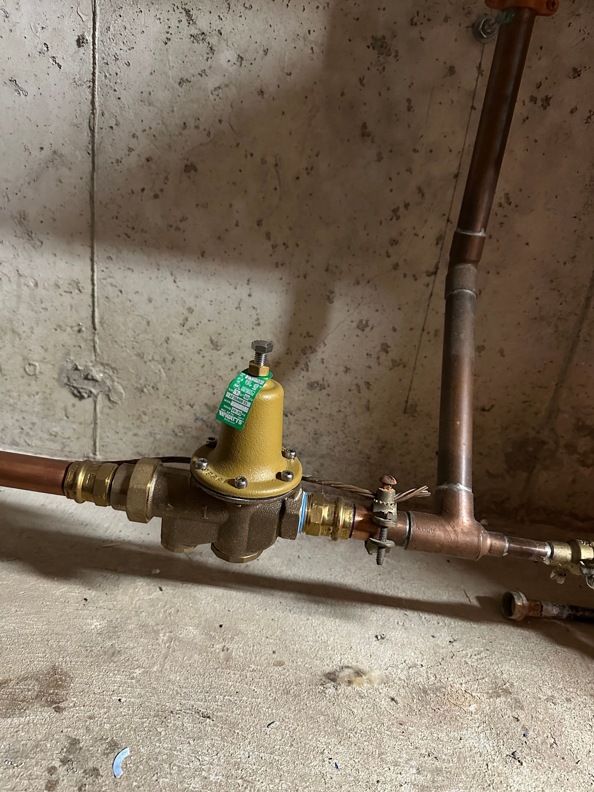 A close up of a copper pipe with a valve on it.