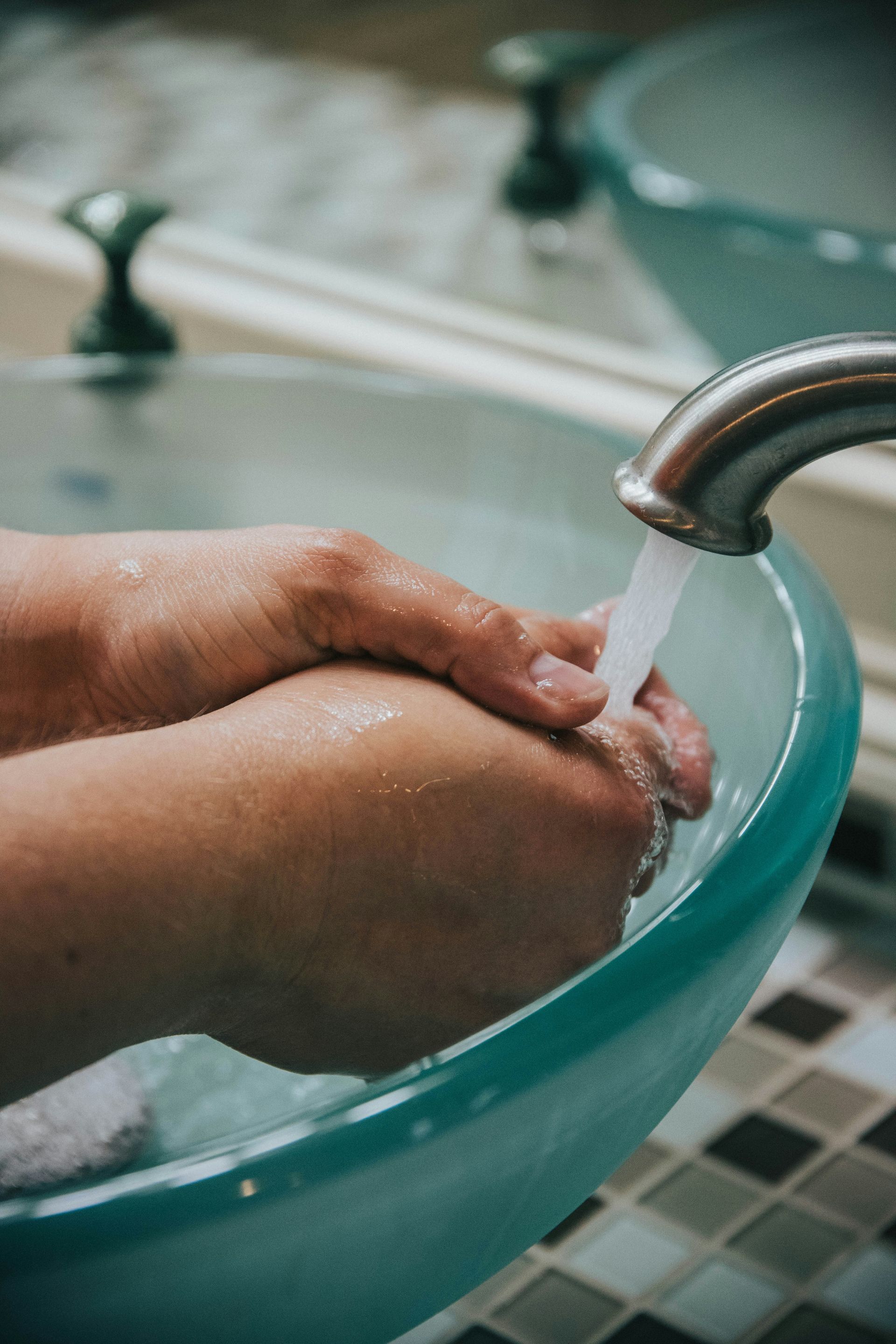 Two women are sitting on the floor in a bathroom next to a bathtub.