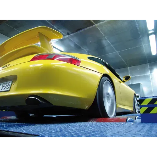 Coche deportivo amarillo en un banco de pruebas, con las ruedas girando.