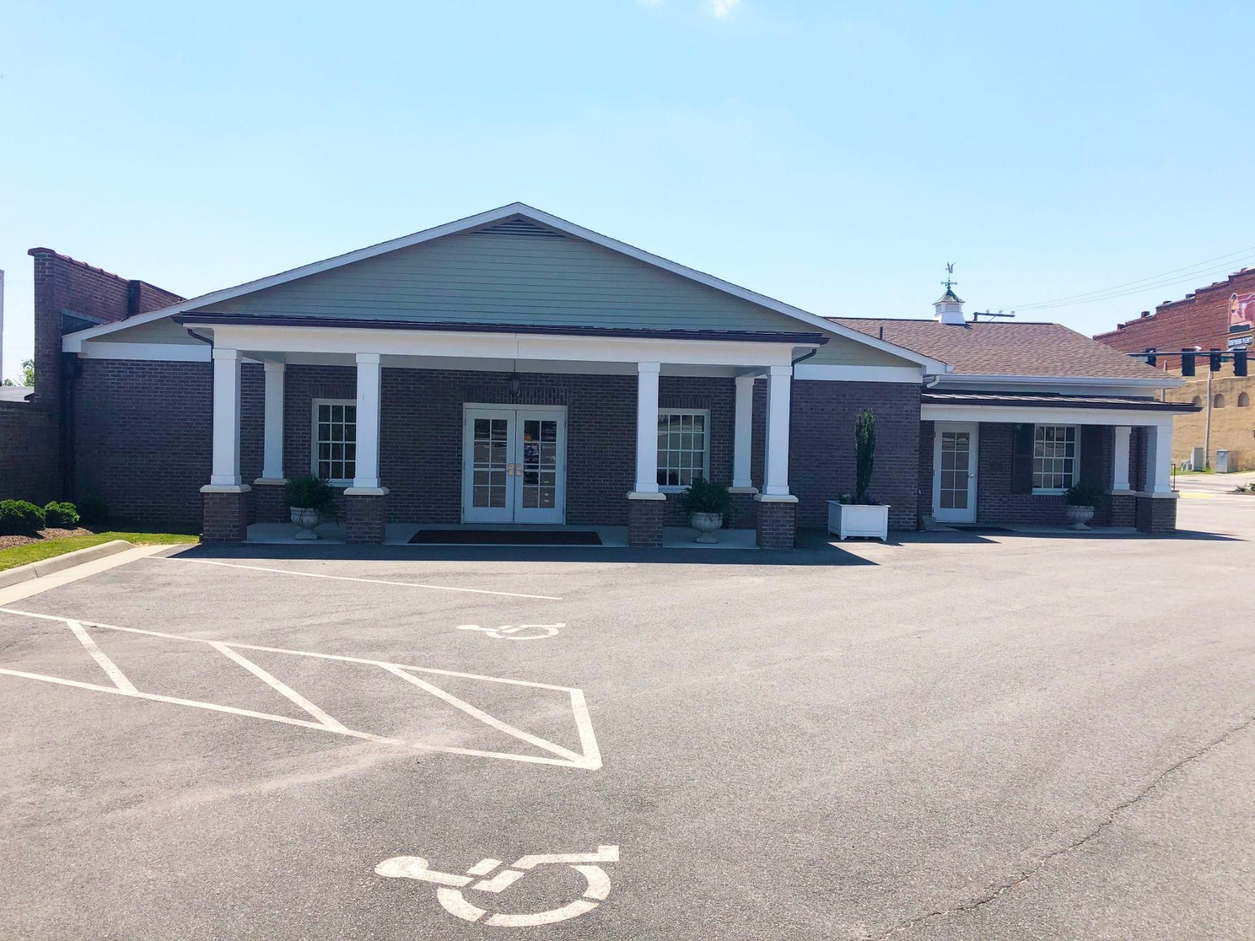 A large brick building with a handicapped parking spot in front of it