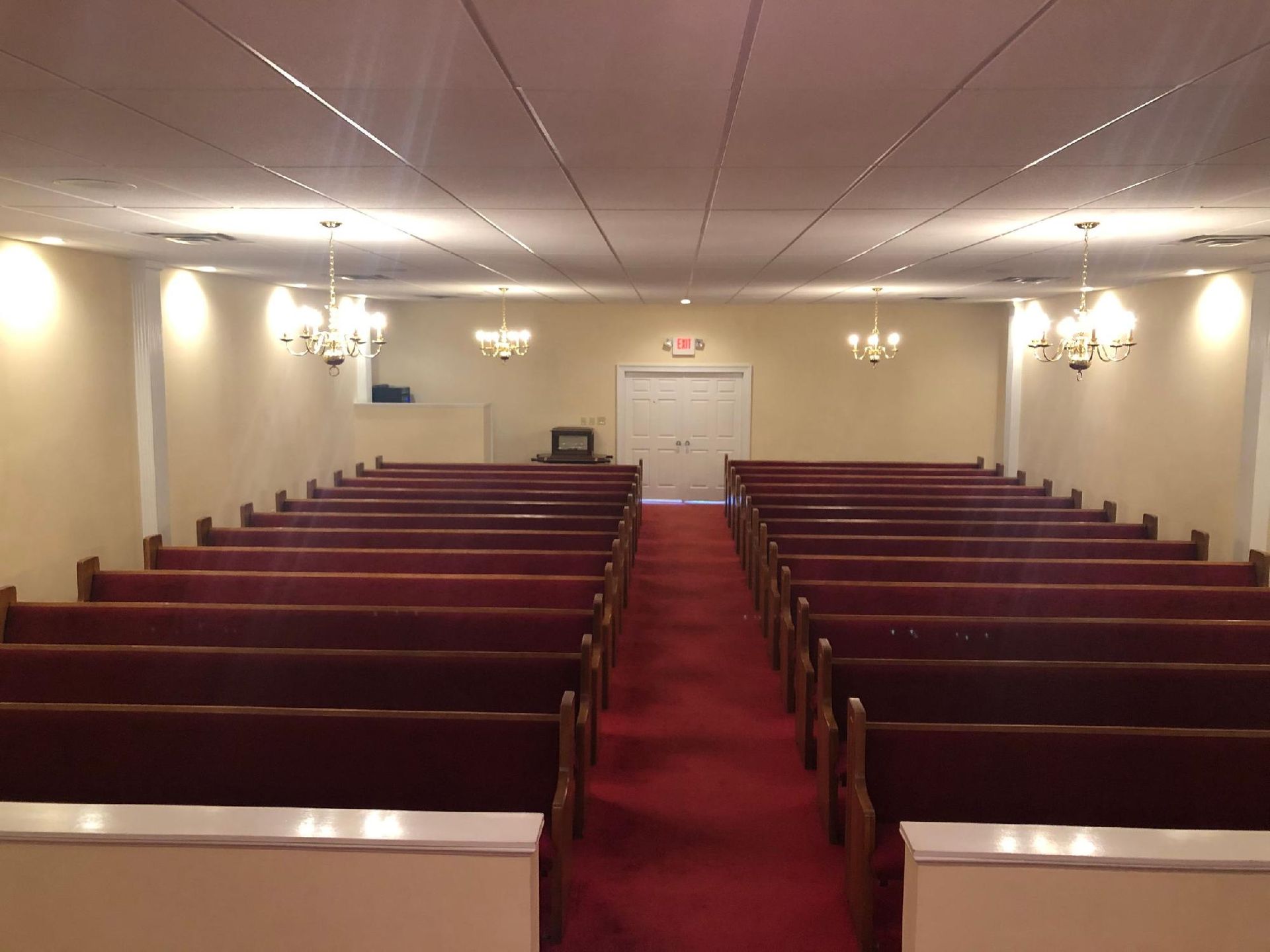 An empty church with red benches and a red carpet