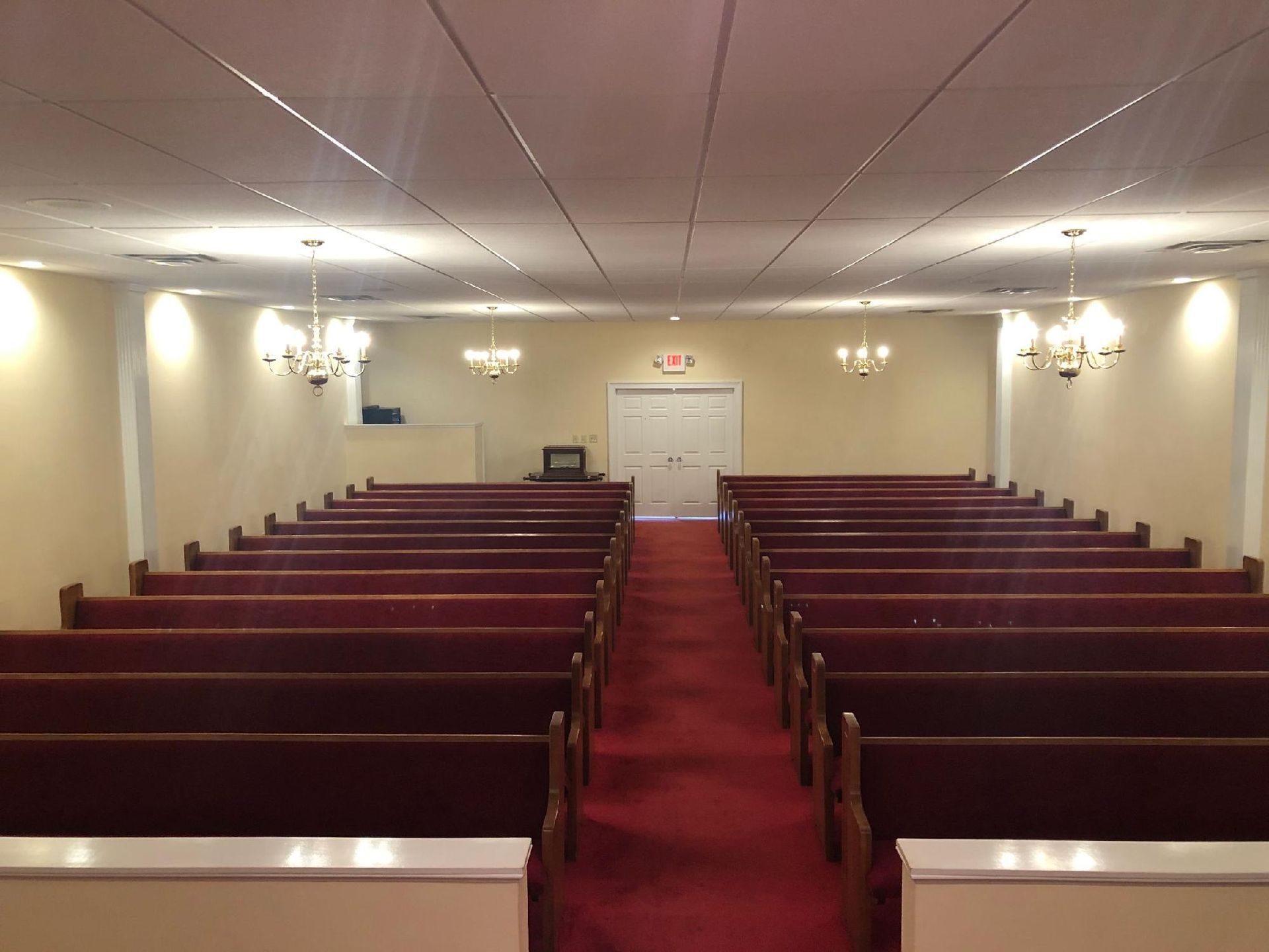 An empty church with red benches and a red carpet