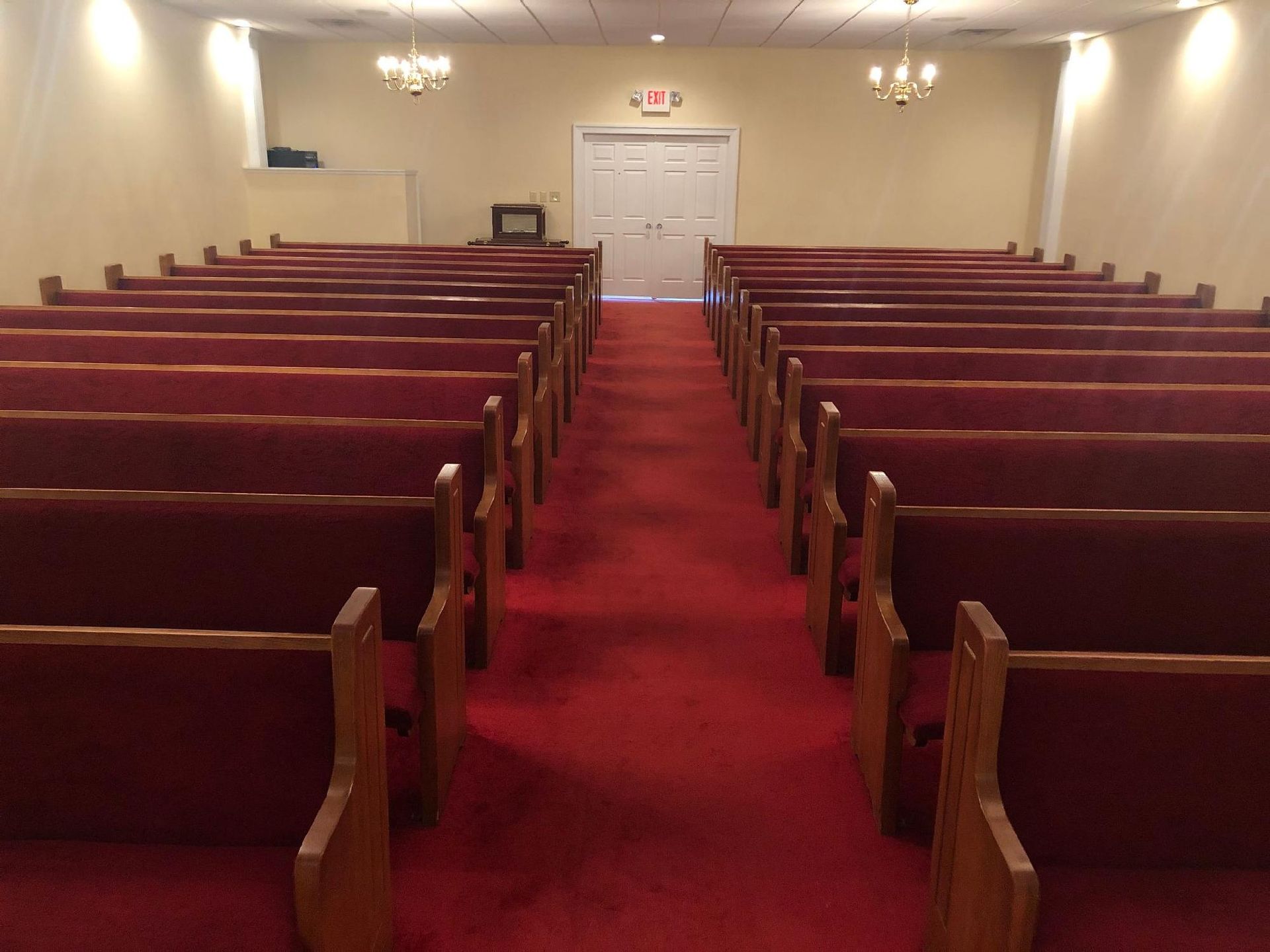 An empty church with red benches and a red carpet