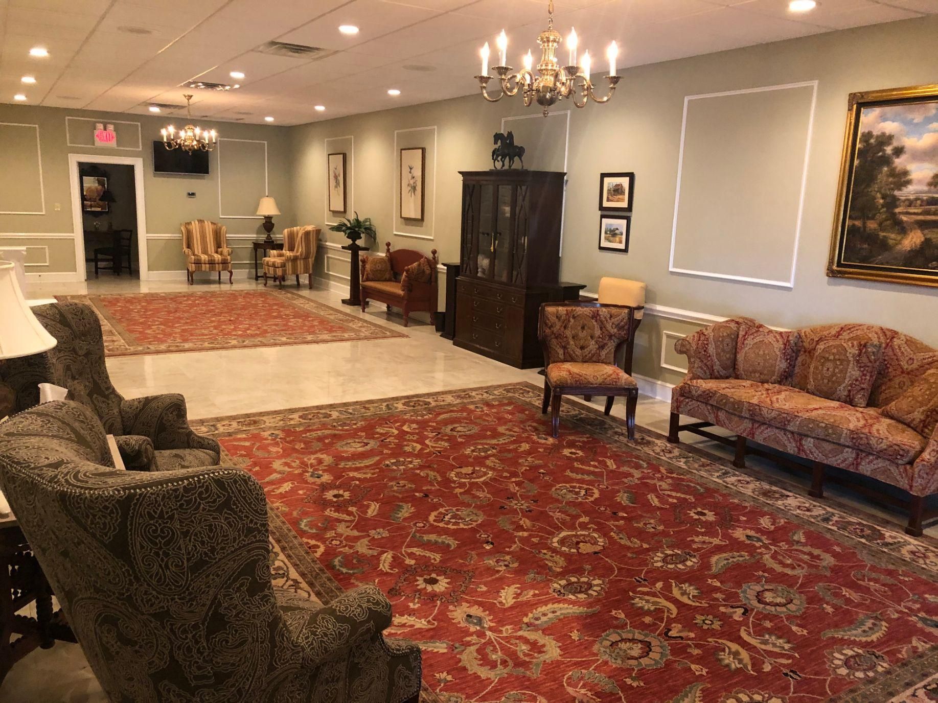 A living room filled with furniture and a red rug.