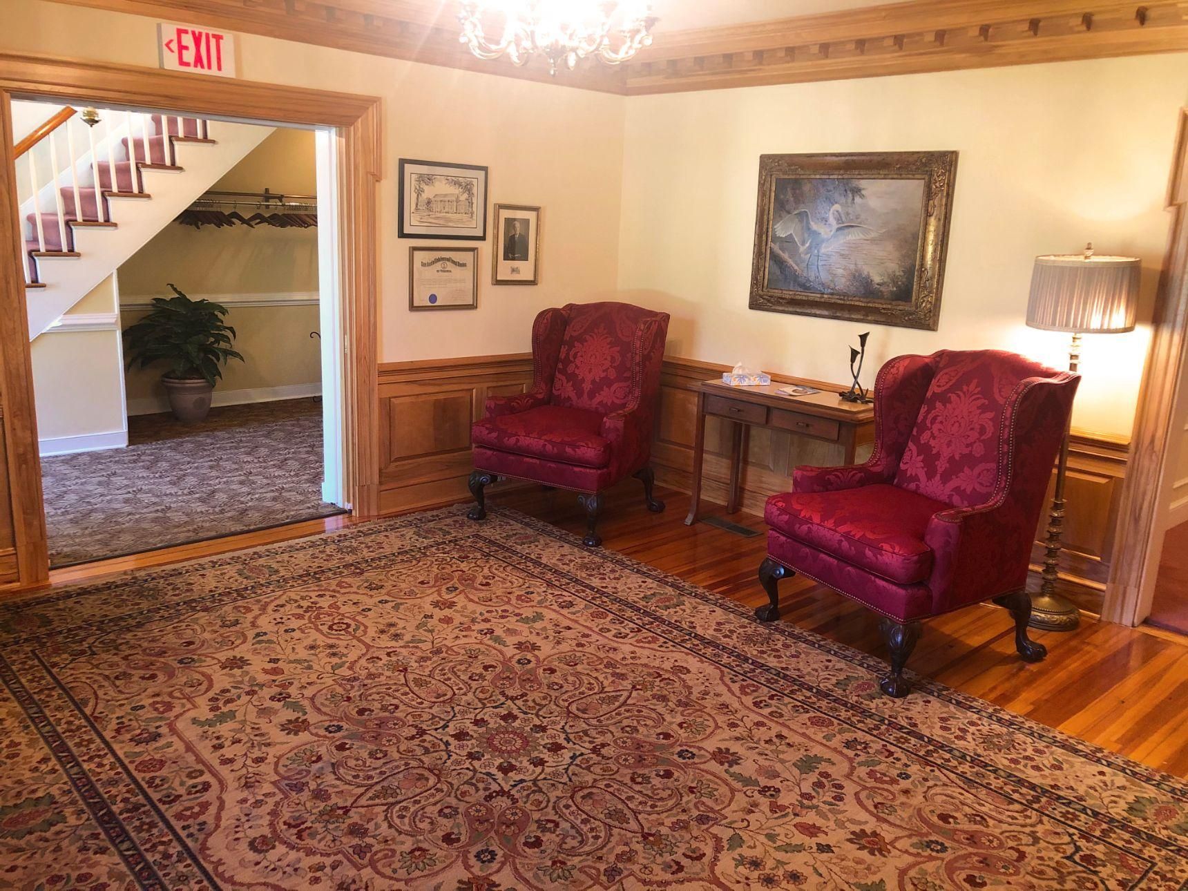 A living room with two red chairs and a rug