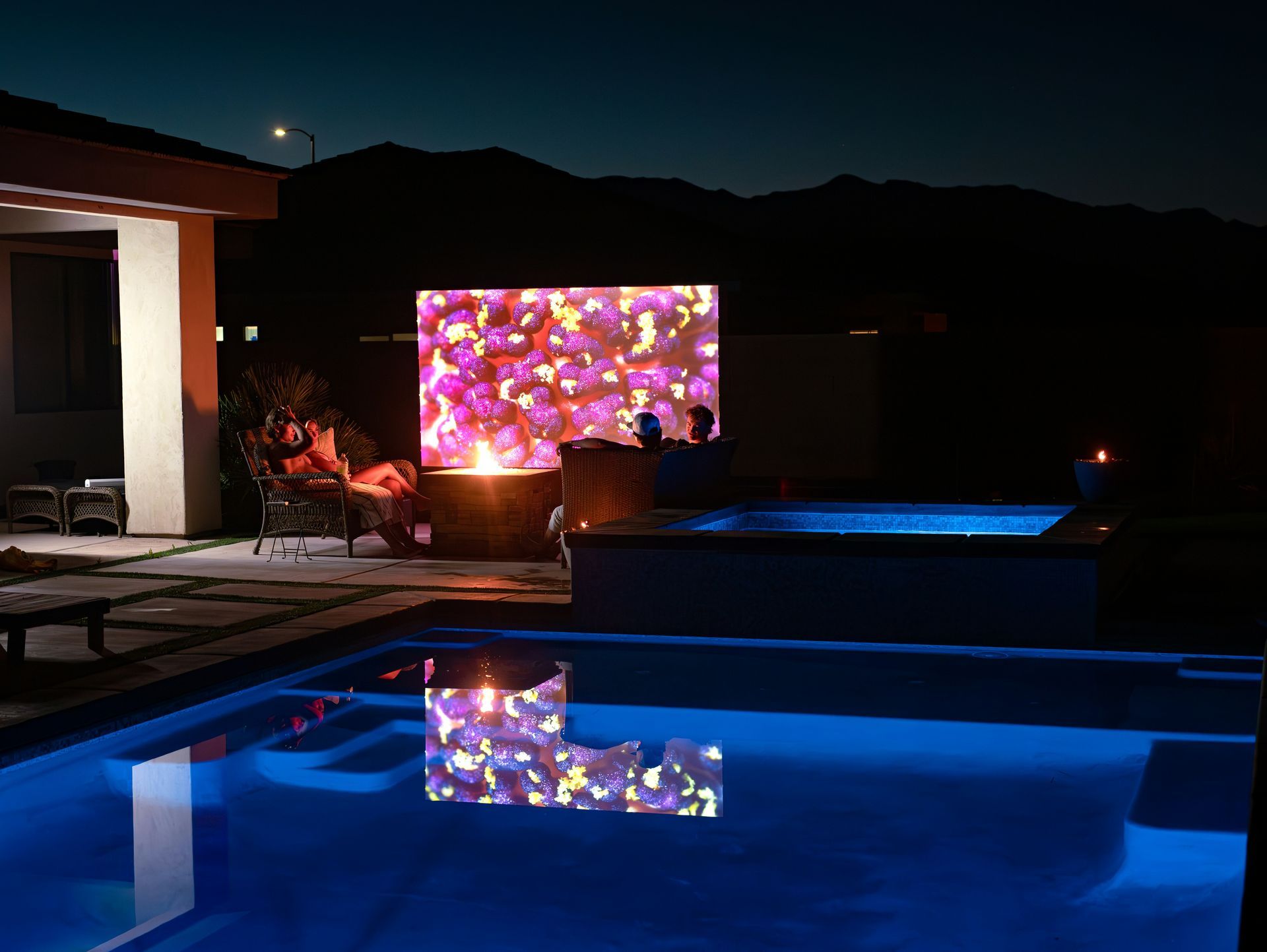 A swimming pool is lit up with blue lights at night.