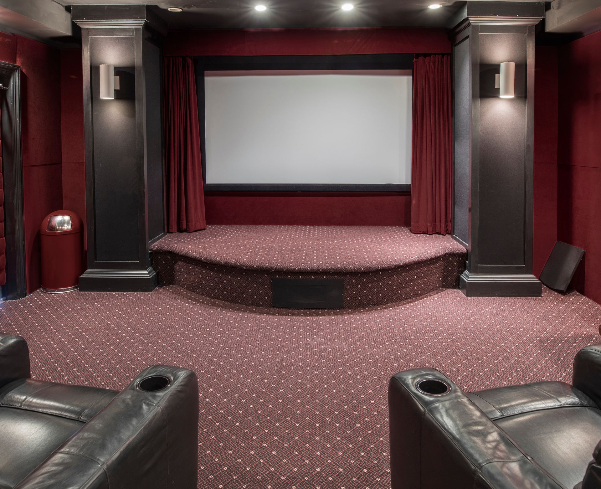 A home theater with two chairs and a large screen