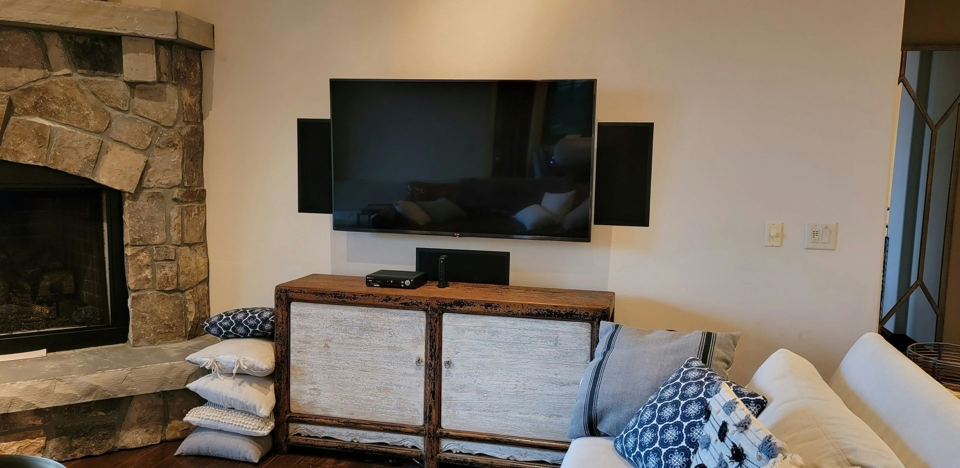 A living room with a fireplace and a flat screen tv on the wall.