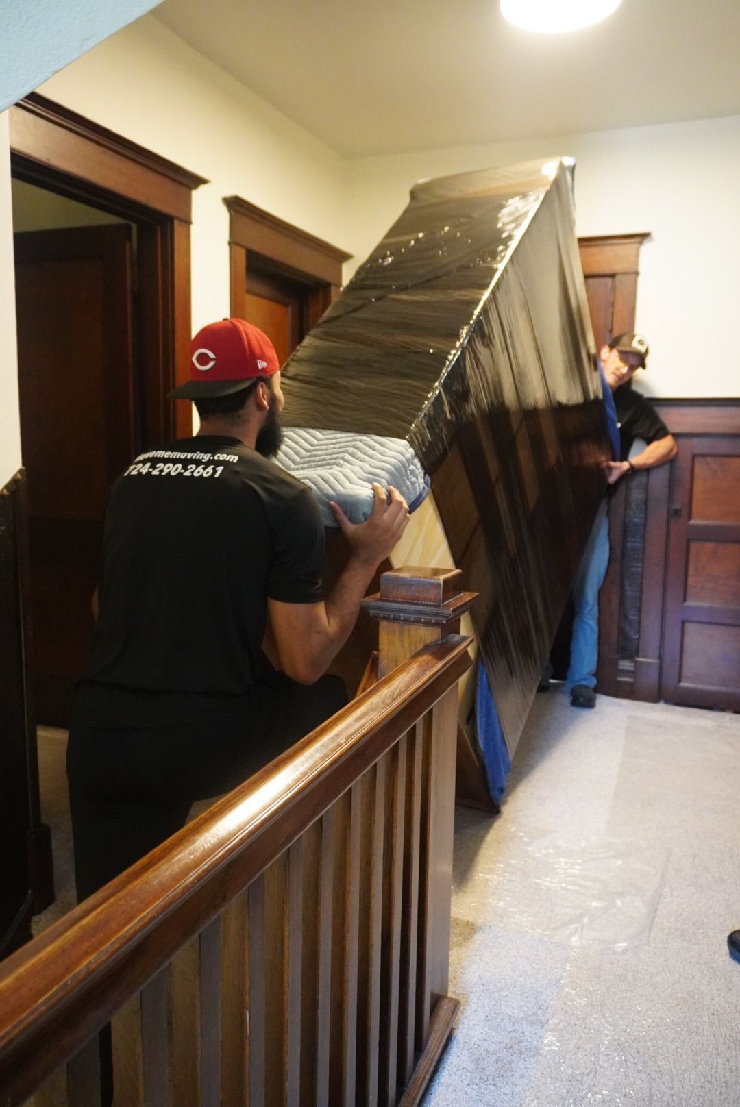 “Happy family standing next to labeled moving boxes inside new Pittsburgh home”
