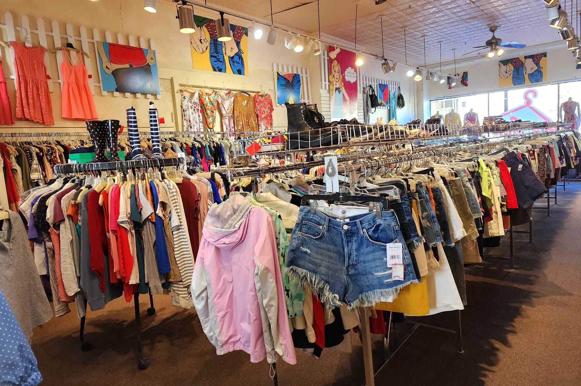 A clothing store filled with lots of clothes hanging on racks.