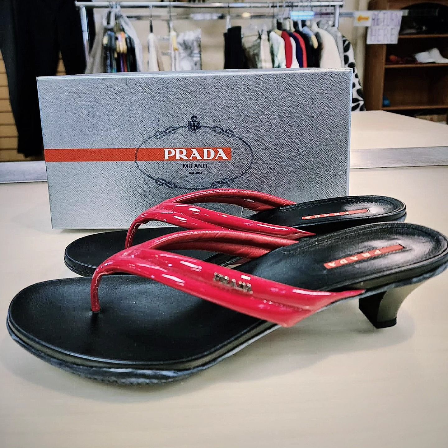 A pair of red and black prada flip flops