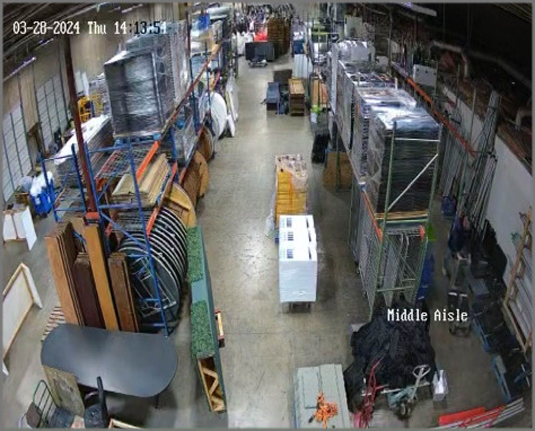 Warehouse interior with shelving, various objects, and a person near the 