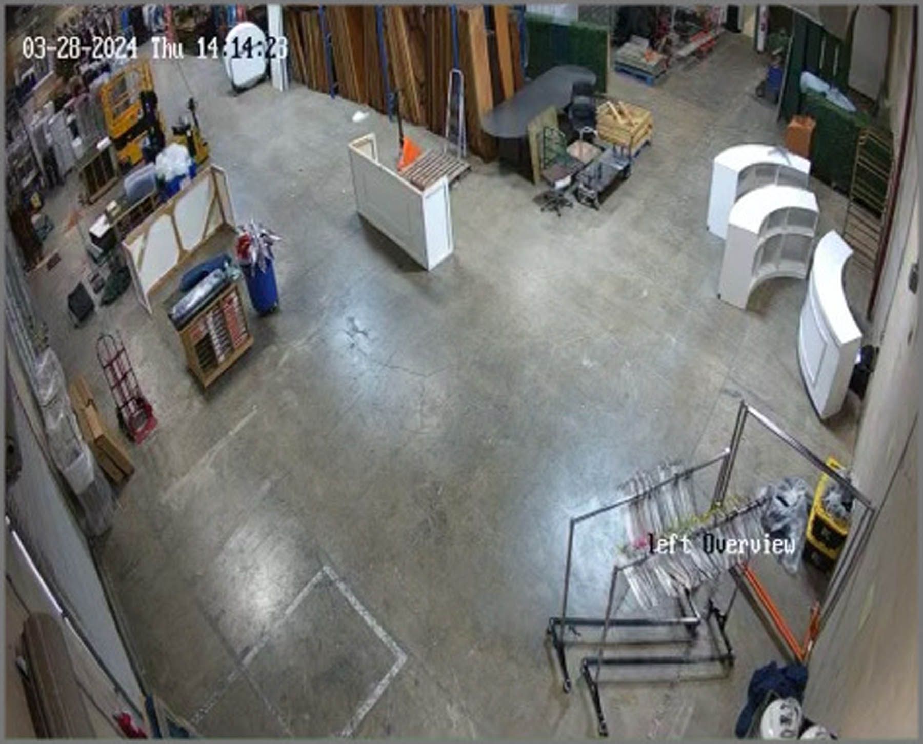 Overhead view of a warehouse interior. Various displays, counters, and shelving are visible.