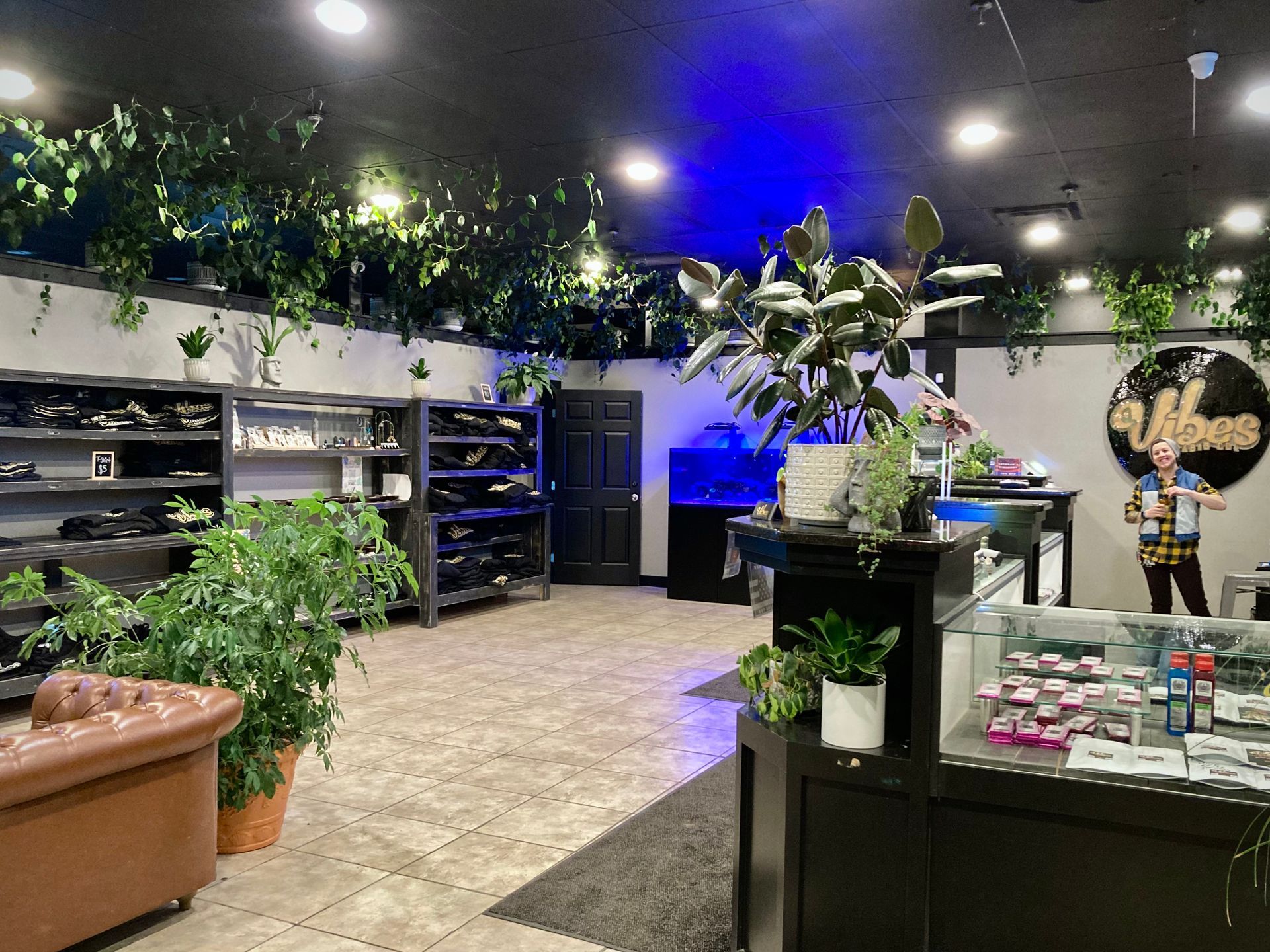 A large room with a lot of plants and a man standing in the middle of it.
