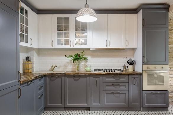 Gray and white kitchen with cabinets, countertops, and a stove.