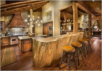 Rustic kitchen with wood bar, stools, cabinets, and appliances; exposed beams and ceiling lights.