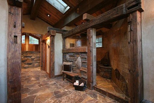 Rustic bathroom with stone and wood accents; shower area and entrance.