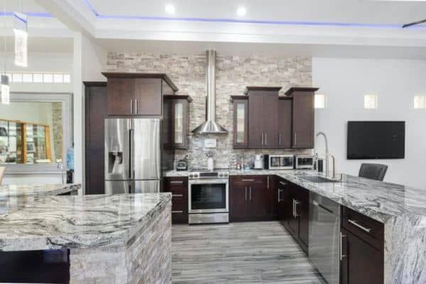 Modern kitchen with dark wood cabinets, stainless steel appliances, and granite countertops.