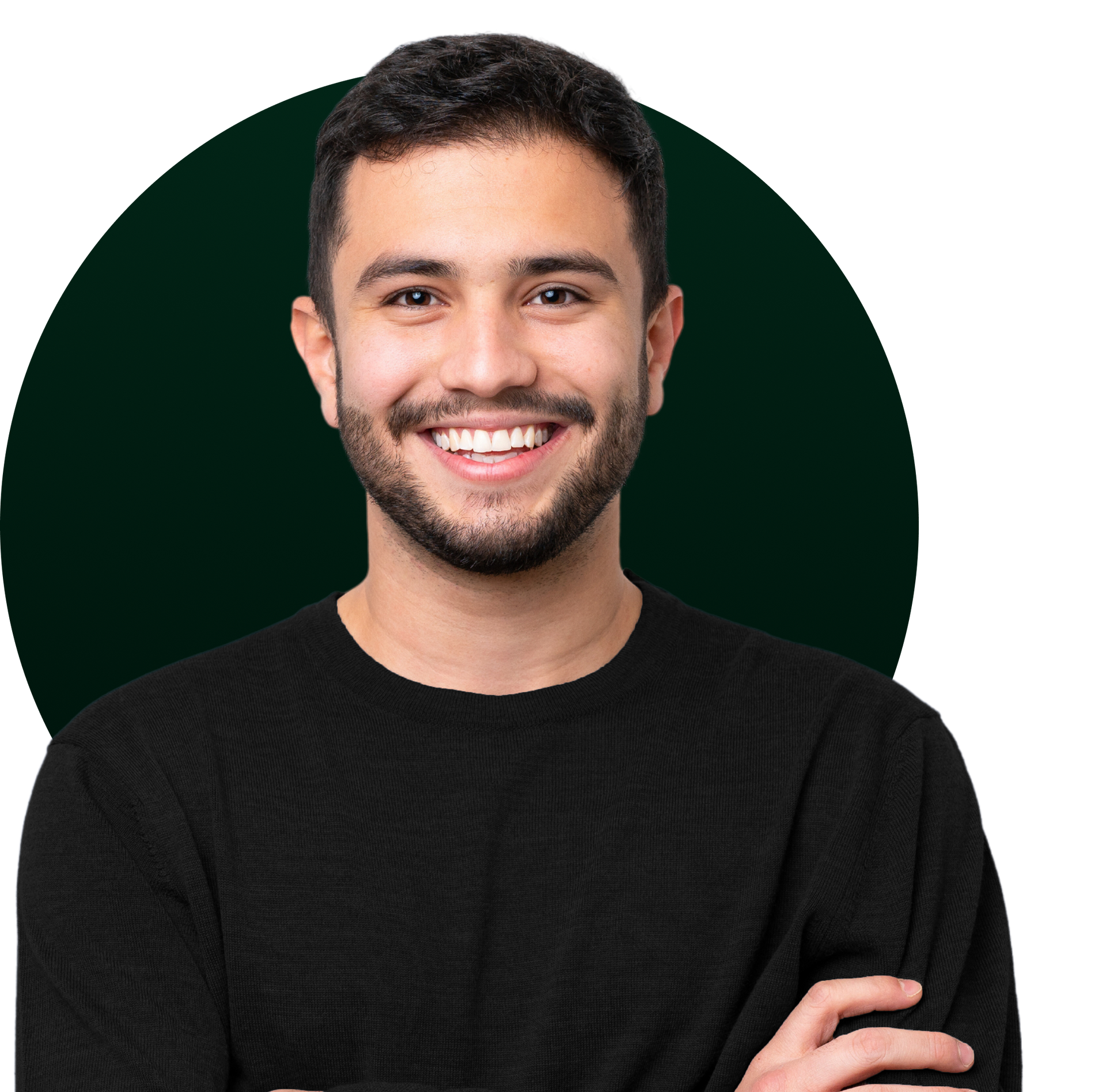 Smiling young man with arms crossed, wearing a black sweater. Dark green background.
