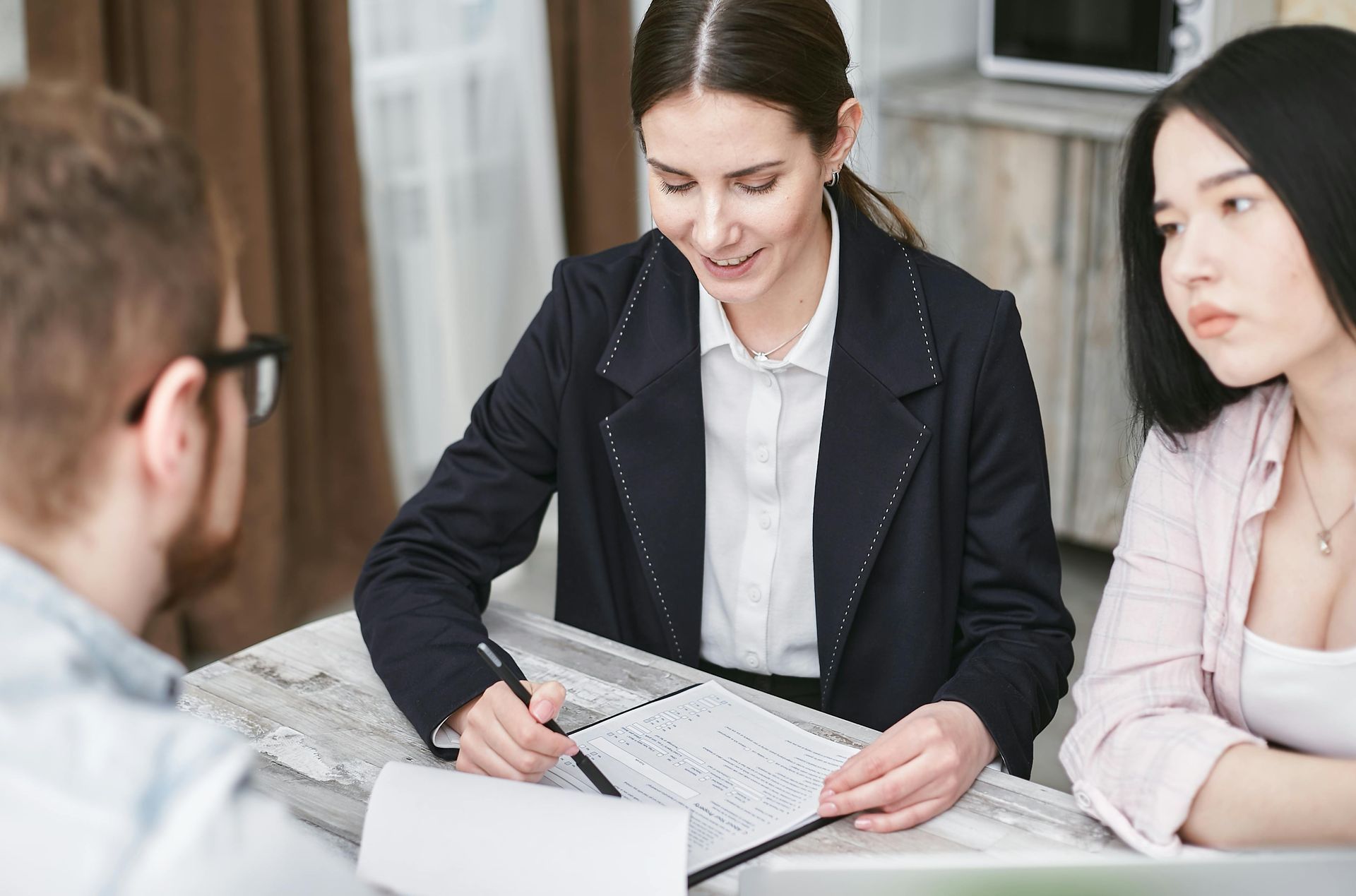 A woman is sitting at a table with a man and a woman.