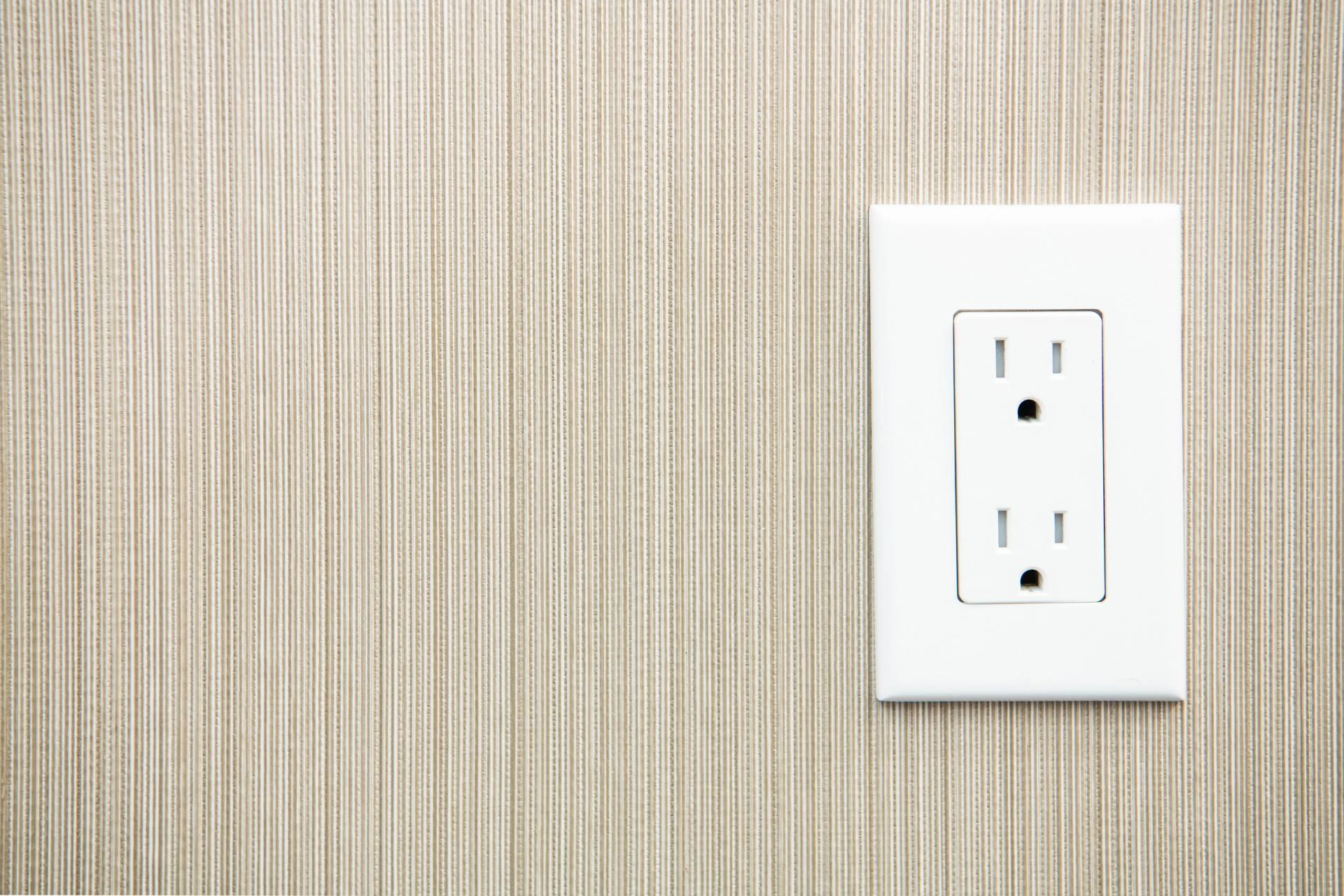 A white electrical outlet on a wooden wall.