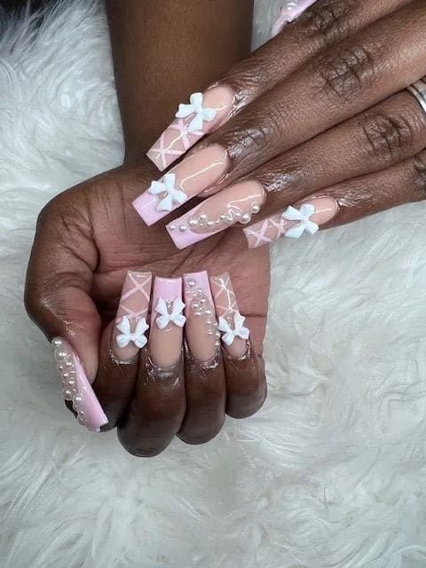 A close up of a woman 's nails with a pink and white design