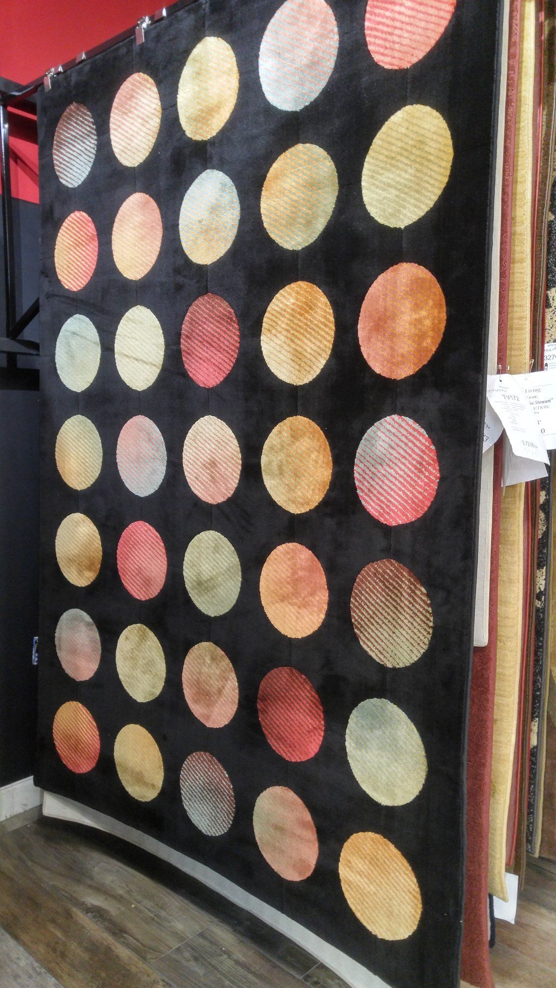 A rug with polka dots on it is sitting on a wooden floor.