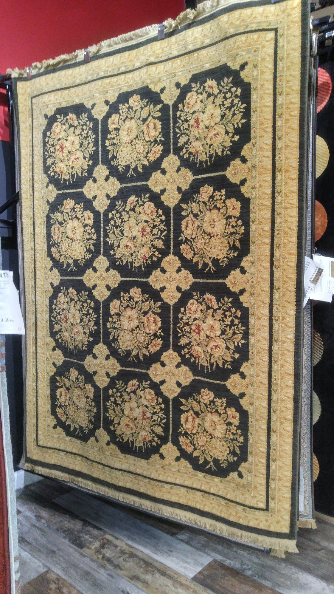 A quilt is sitting on a wooden floor in a store.