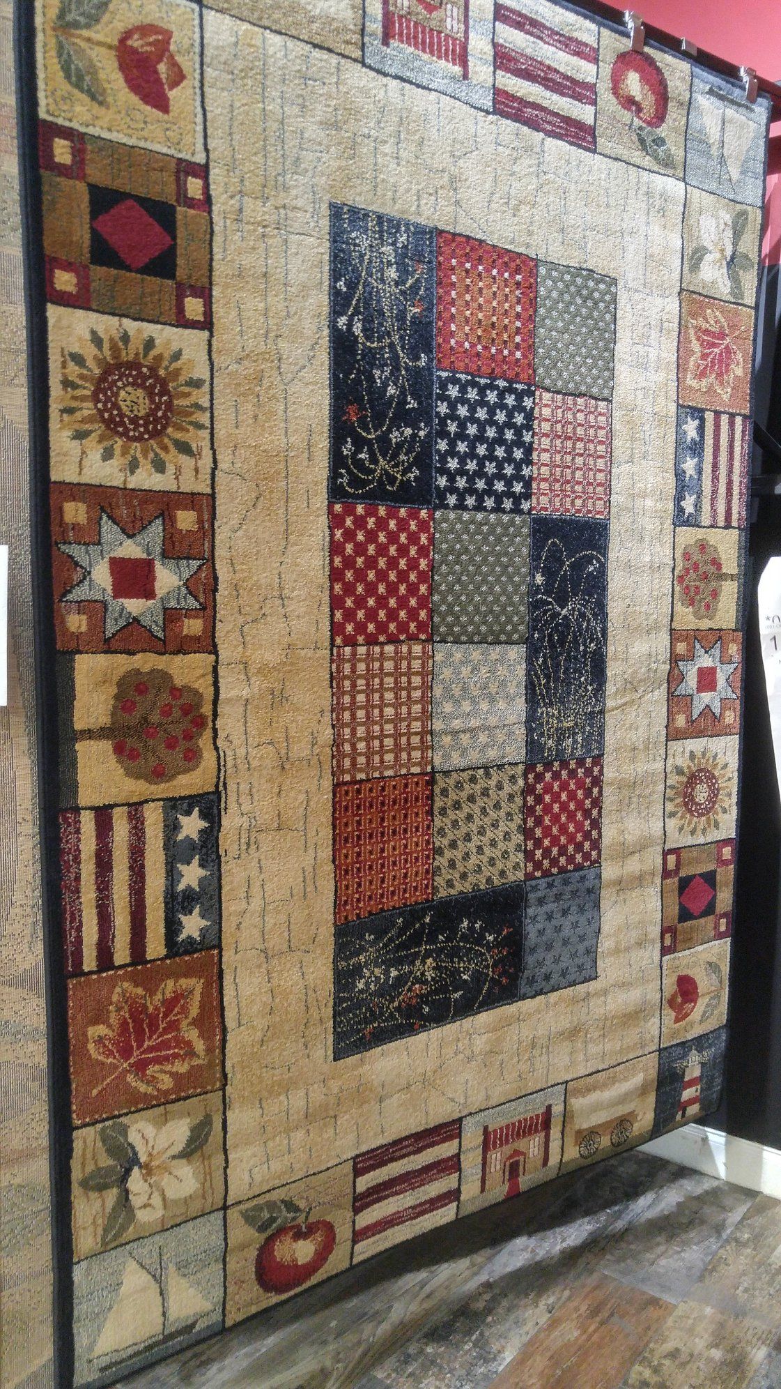 A quilt is hanging on a wall in a room.