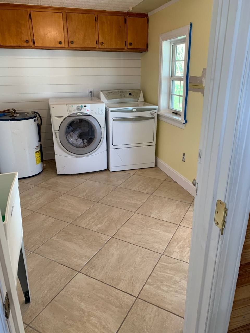 A laundry room with a washer and dryer and a window.